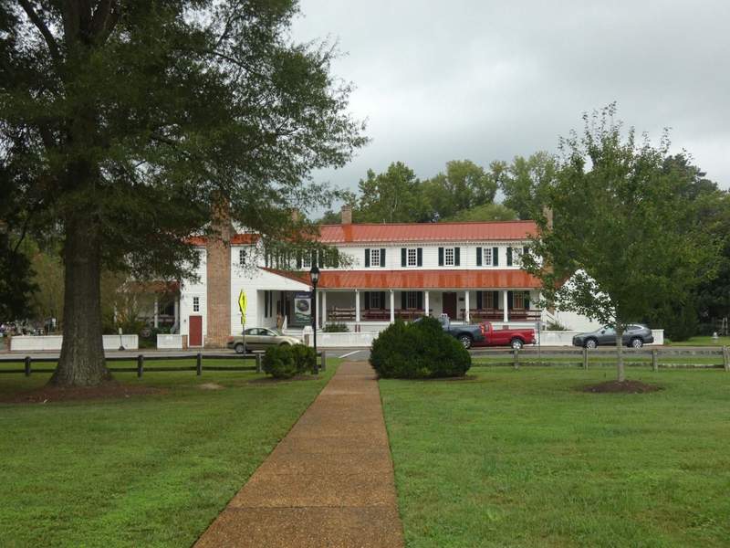 A white frame colonial building with a red roof.