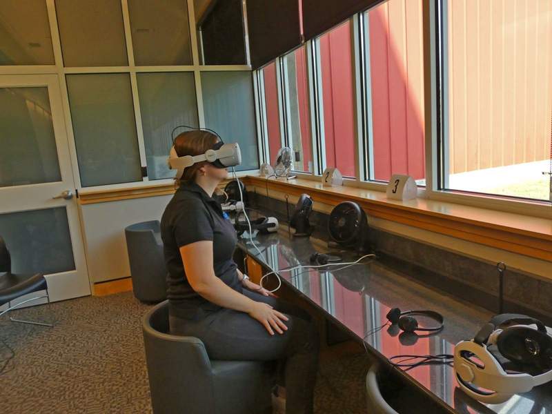 A woman viewing through virtual Reality glasses.