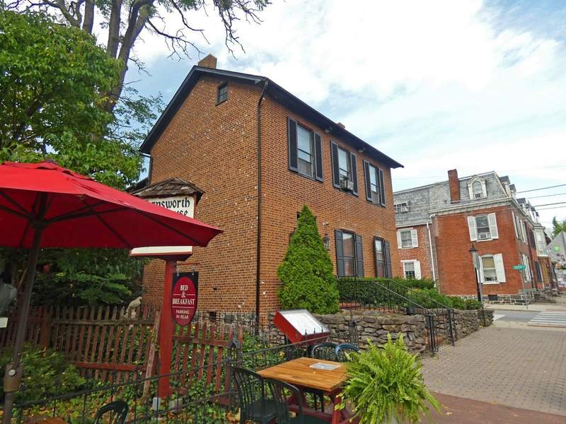 A red brick building nest to a patio with a red umbrella.