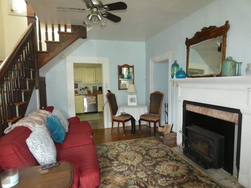 Living room furnished with a red sofa and round table an d chairs with a fireplace,