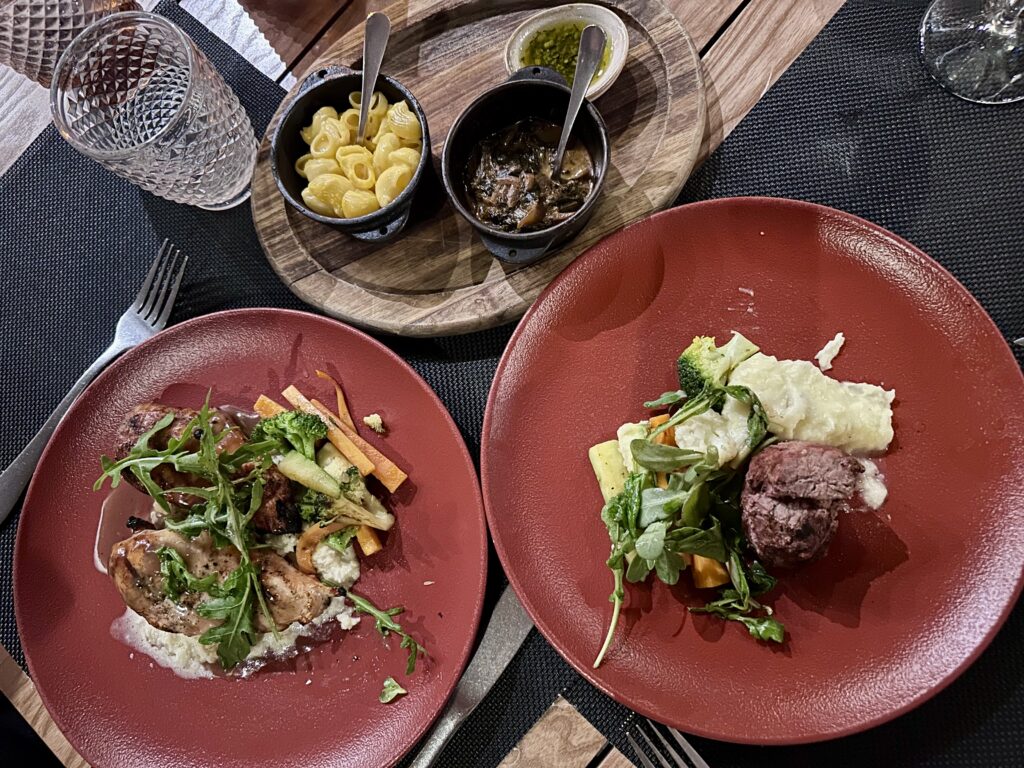 Steak and chicken entrees with sides at JWB Steakhouse at Margaritaville Island Reserve Riviera Maya