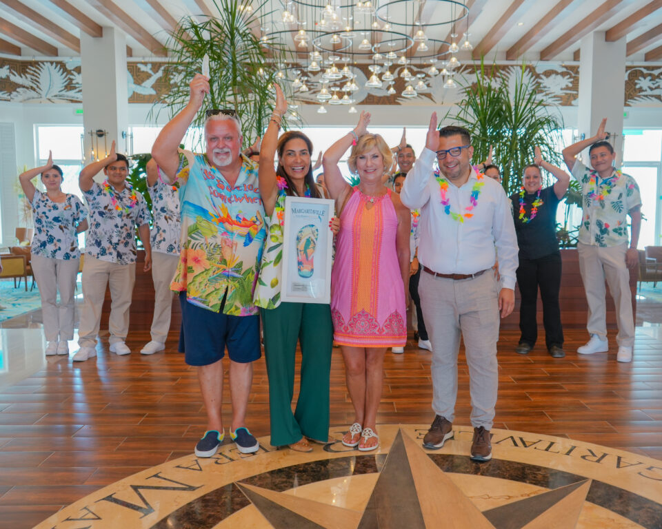 Guests at Margaritaville Island Reserve Riviera Maya demonstrating the "Fins Up" greeting.