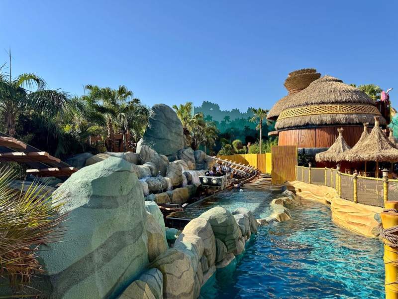 Riders on a jungle-themed roller coaster