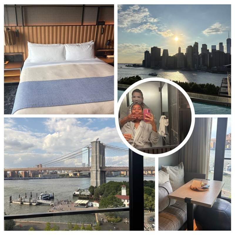 The author and her partner with face masks on in the hotel room. A bed, living room space, and city view of the Brooklyn Bridge and city skyline.