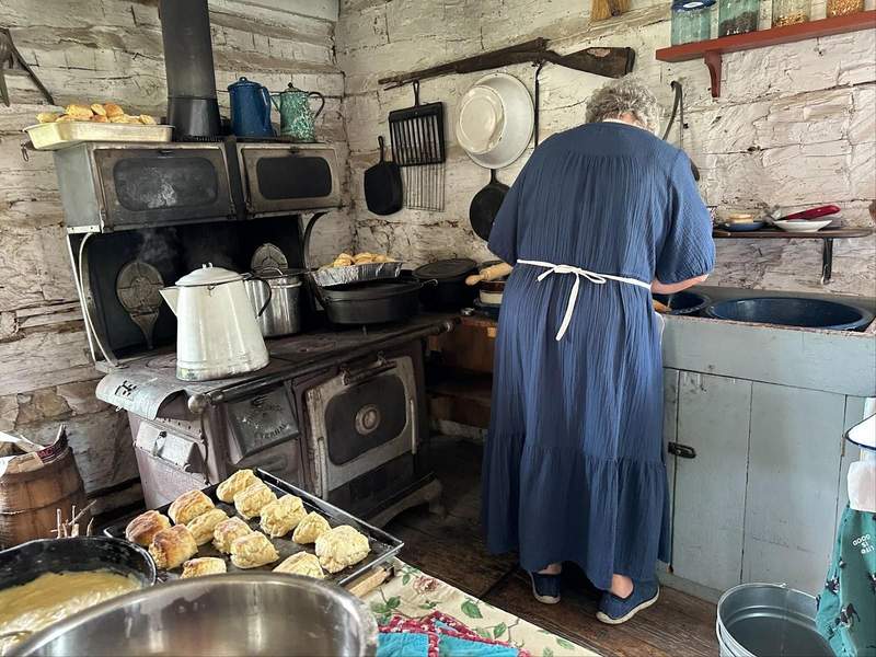 A woman cooking in period costume at the Dickinson County Heritage Center, a stop on the Kansas Gunsmoke Trail