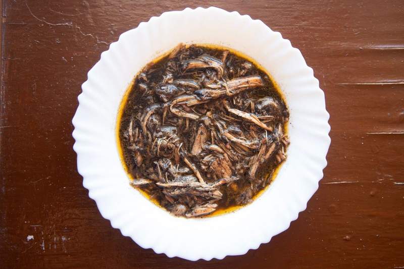 Bowl of shredded turkey stew cooked in black seasoning.