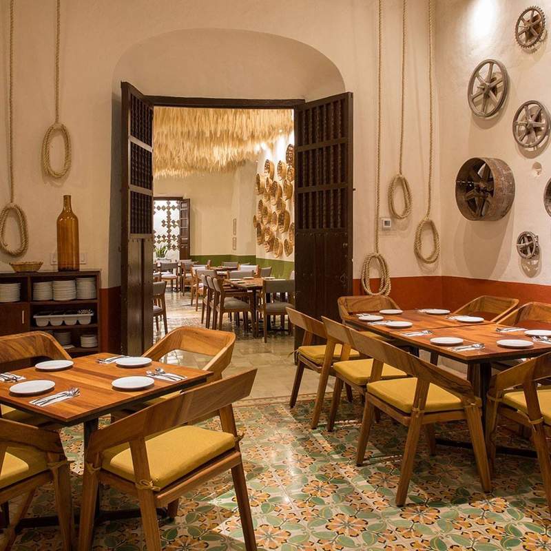 Restaurant with colorful floors, wooden tables and rustic decor.