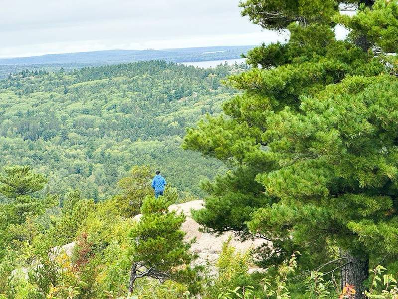 Man in blue hoodie looking at view from Sugarloaf Mountain