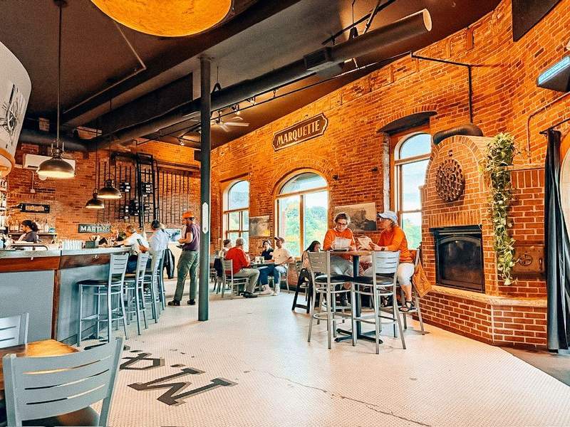 Restaurant interior with brick walls and a Marquette sign
