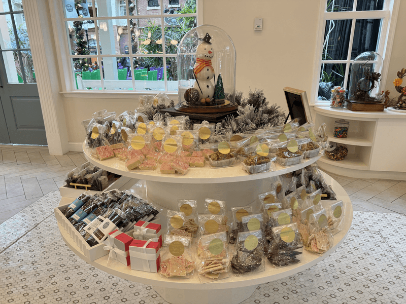 A white table with candy and a snowman on top.