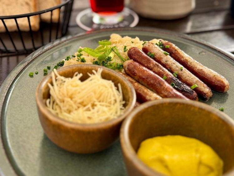 Plate of grilled Nuremberg sausages with sauerkraut and mustard, served at a restaurant in Nuremberg, Germany.
