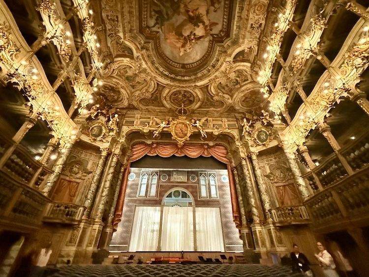Interior view of the Margravial Opera House in Bayreuth, showing the ornate Baroque stage, gilded decorations, and intricate architectural details.