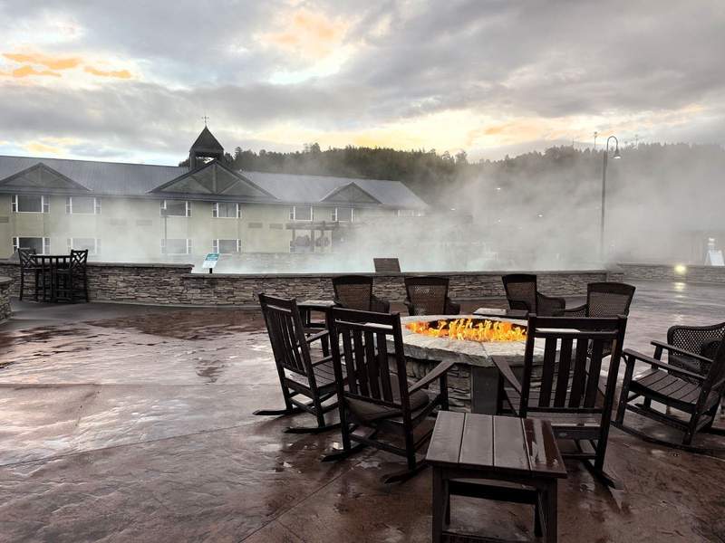 Steam rises off The Mother Spring at The Springs Resort & Spa in Pagosa Springs, Colorado with a firepit nearby.