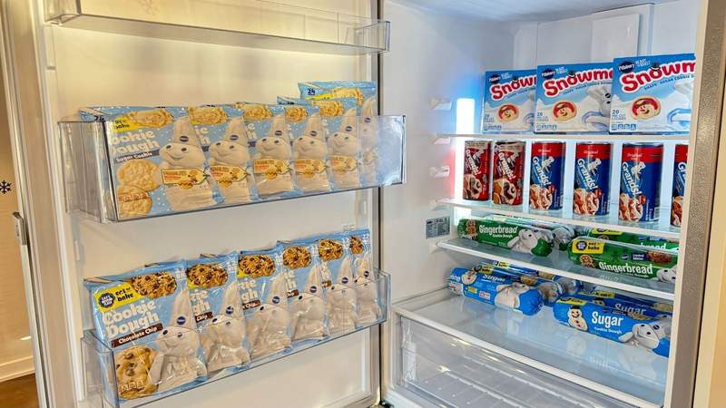 Fully stocked fridge lined with nearly 50 boxes of Pillsbury holiday cookies and cinnamon rolls on the shelves at the Pillsbury Let It Dough suite.