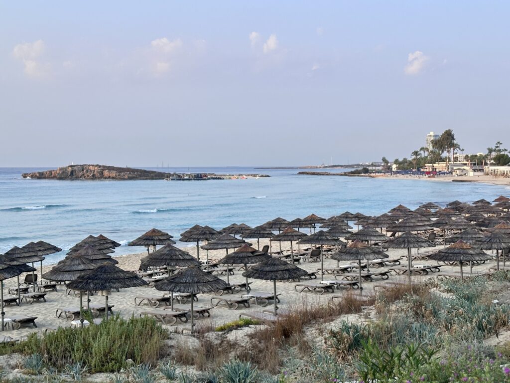 Thatched umbrellas and sun beds fill Nissi Beach in Cyprus, location of the Nissi Beach Resort.