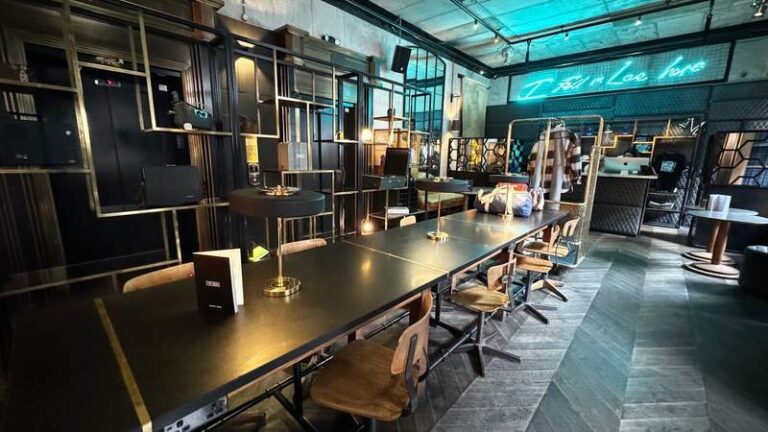 long black table with lighting fixtures and desk chairs inside a lobby area at the dean dublin