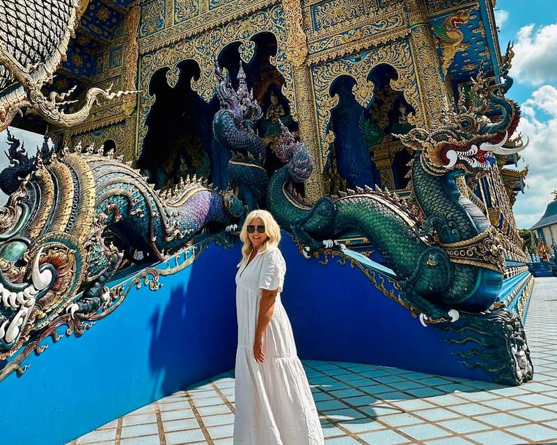 woman standing in front of a colorful temple in Chiang Mai Thailand