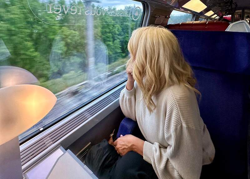 woman sitting on a train in Spain during a budget-friendly trip