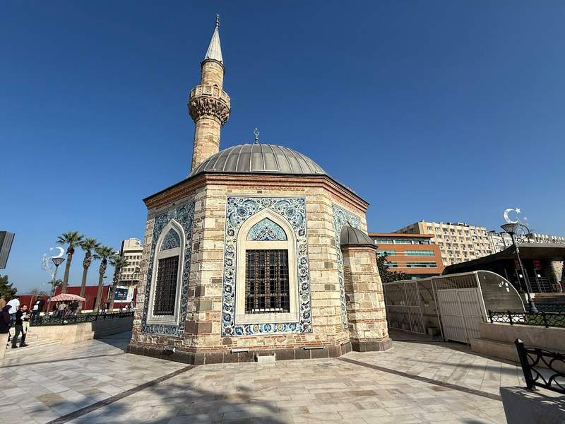 A small 1-room mosque and minaret with Islamic artwork on sides.