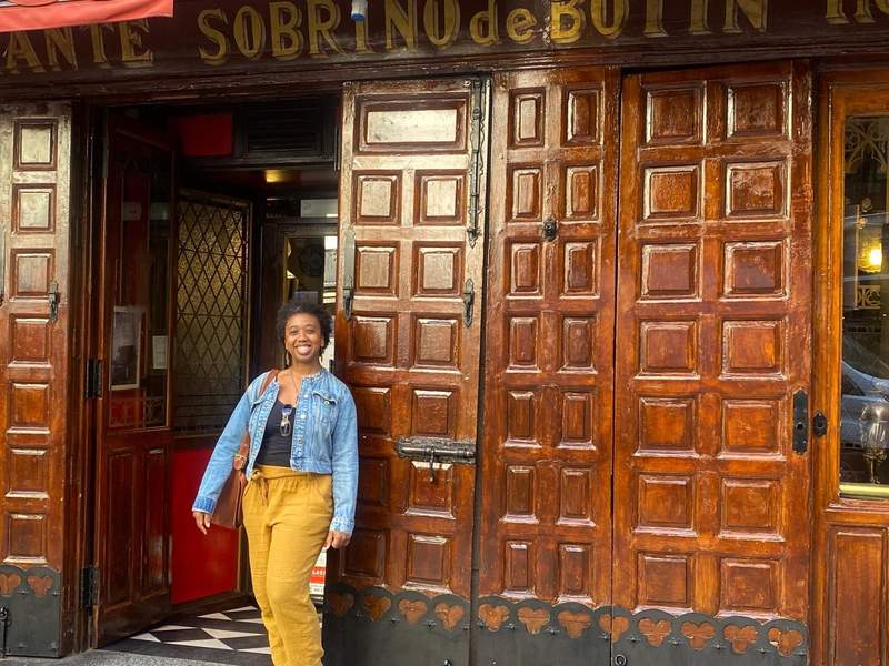 Women standing outside a building with large wooden doors