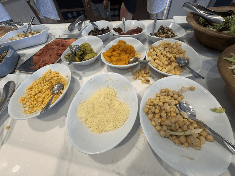 Food in white dishes at a breakfast buffet.