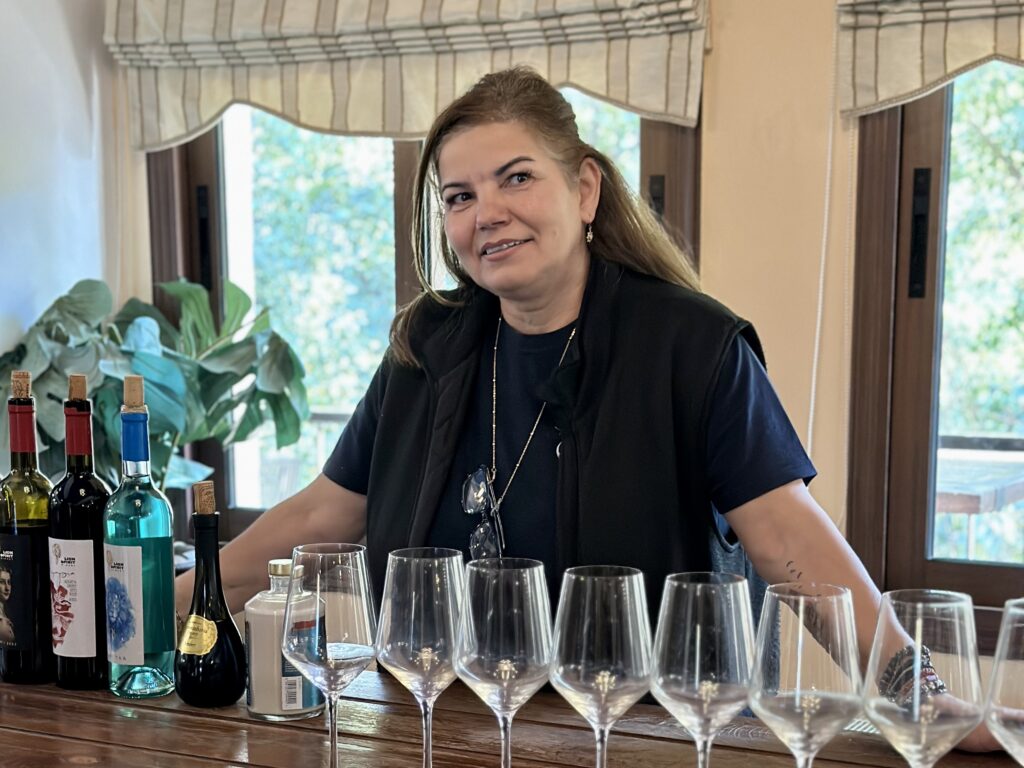 Woman behind wine glasses and bottles at LionSpirit winery and distillery In Cyprus.