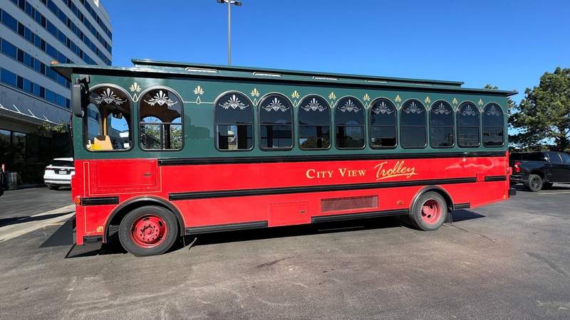 red and green trolley with geometric windows in a parking lot in south dakota.