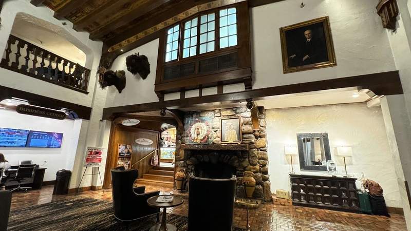 wooden lobby with photo of Andrew Johnson on wall next to a fireplace and taxidermy buffalos at Hotel Andrew Johnson in South Dakota. 