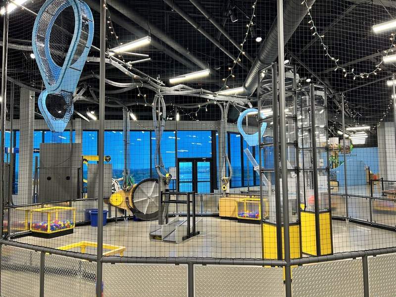 A hands on gallery to demonstrate basic engineering skills includes pulleys tubes and blowers and boxes of colored balls