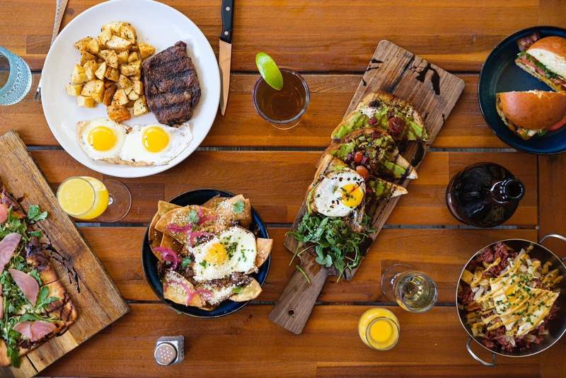 A spread of different dishes on a wood table at Public House in Temecula.