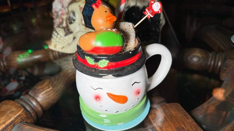 snowman mug with rubber duck and santa stick on a wooden table in Solvang. 