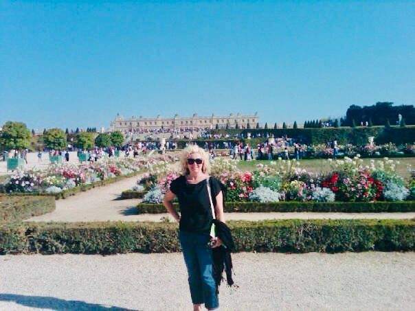 woman walking in the gardens of Versailles in Paris during a springtime vacation