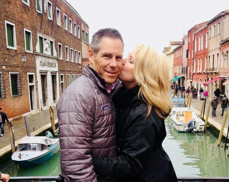 woman and her husband standing on a bridge overlooking a canal on Murano Island in Italy