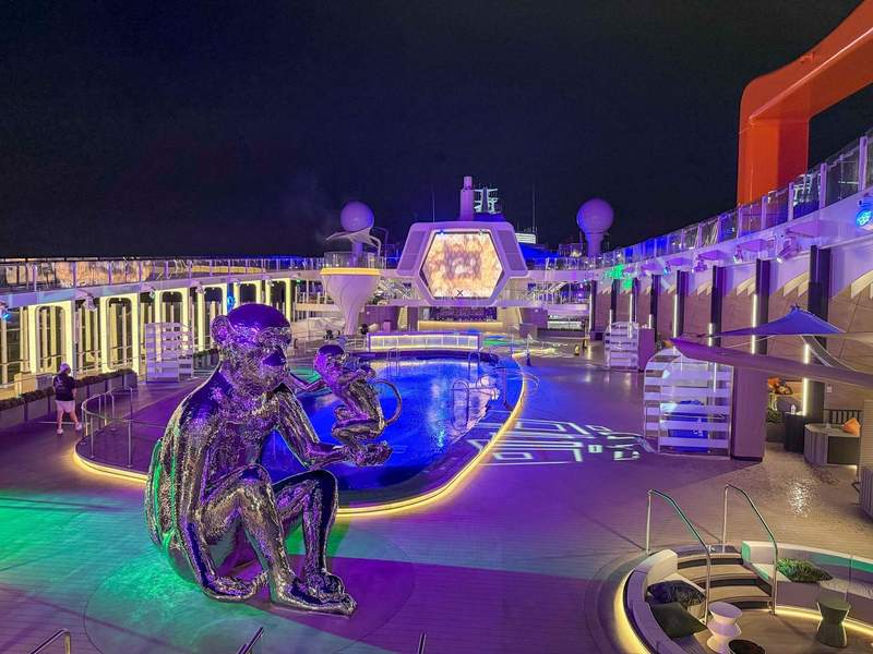 Cruise ship pool with monkey sculpture at night