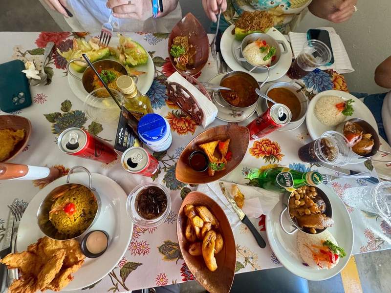 A table filled with Puerto Rican dishes like fried plantains and stuffed avocado