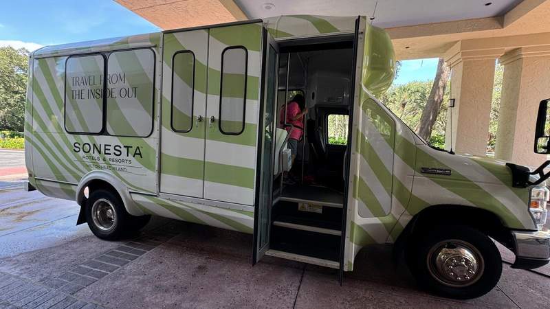 green and white mini charter bus on pavement with doors open at Sonesta Resort Hilton Head Island. 