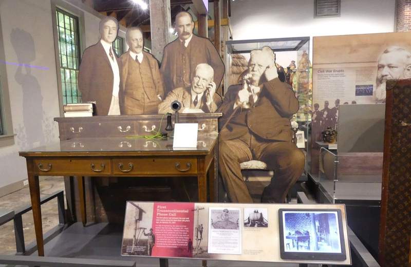 Men in early 1900s suits making a phone call,