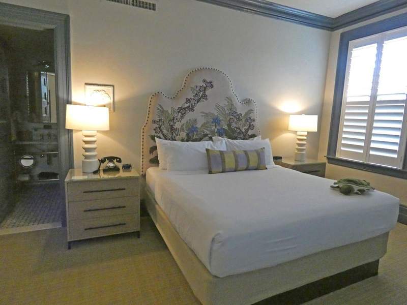 Bedroom in a hotel with nightstands,lamps and a rotary phone.