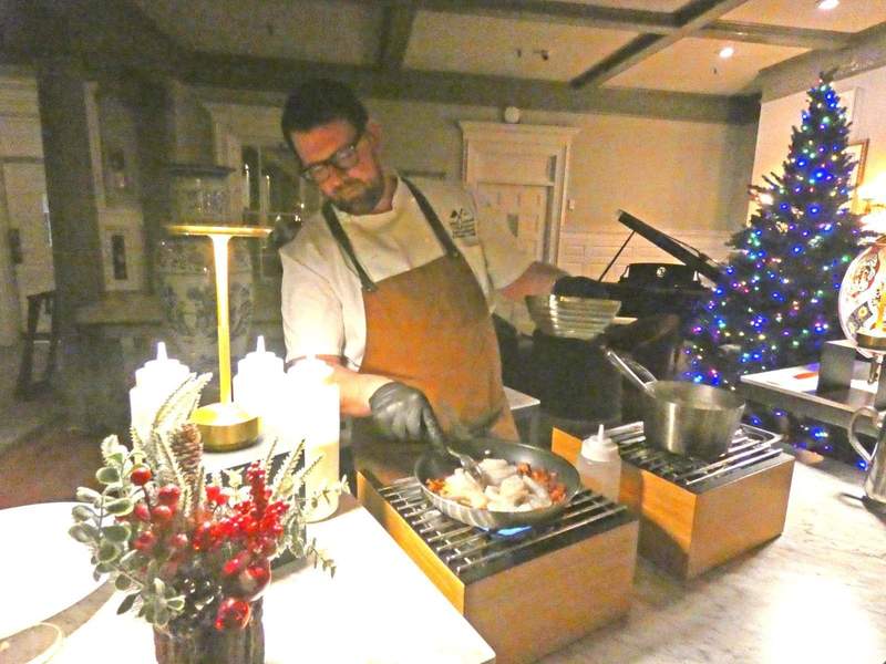 A chef preparing food on a counter decorated for Christmas