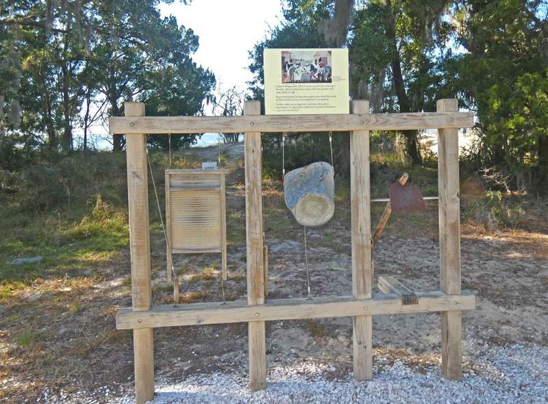 An exhibit on a beachfront showing washboard. bucket and a hoe used by enslaved people as music instruments.