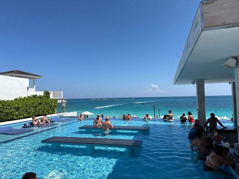 Photo shows the rooftop pool bar at Hotel Riu Palace, showing the swim up bar overlooking crystal blue water