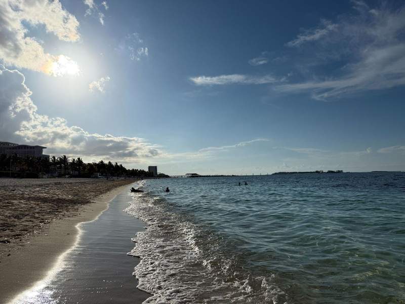 Photo of the beachfront at Breezes Bahamas showing the waves coming onto shore and looking down the shoreline