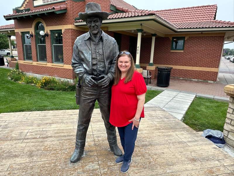 Woman beside the Matt Dillon statue in Dodge City on the Kansas Gunsmoke Trail.