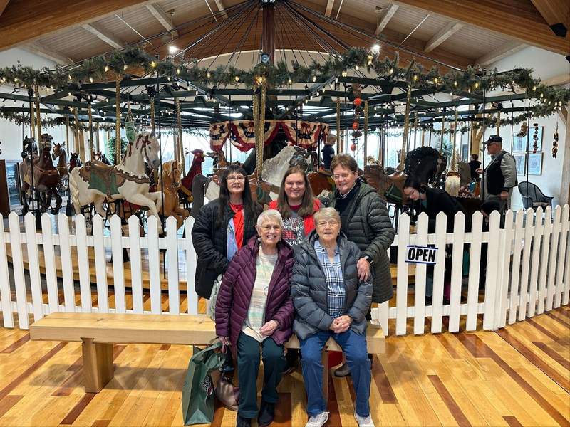 Five ladies in front of a Carousel.