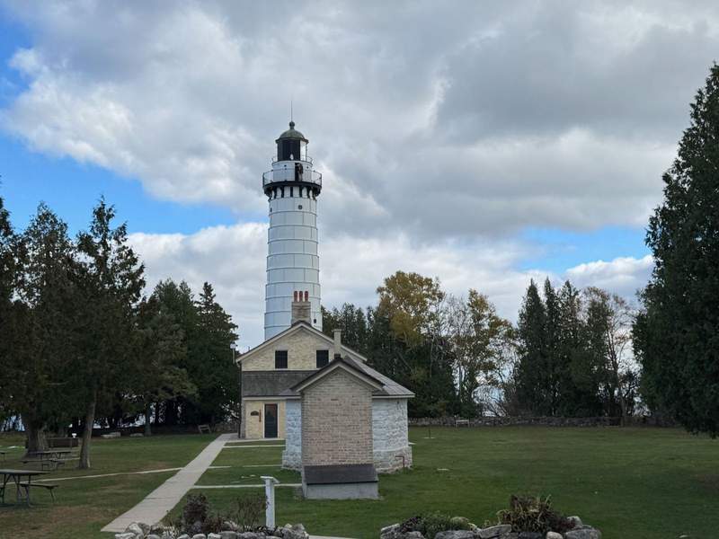 Lighthouse  surrounded by green landscape