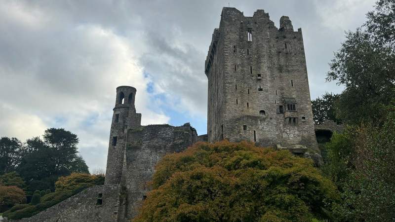 two large stone structures infront of green trees at Blarney Castle