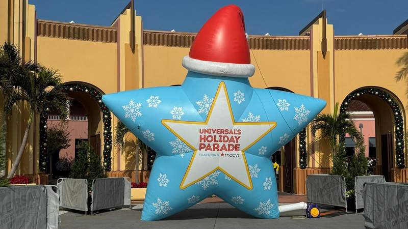 blue star with snowflakes and a red santa hat and text that says universals holiday parade featuring macys at universal orlando