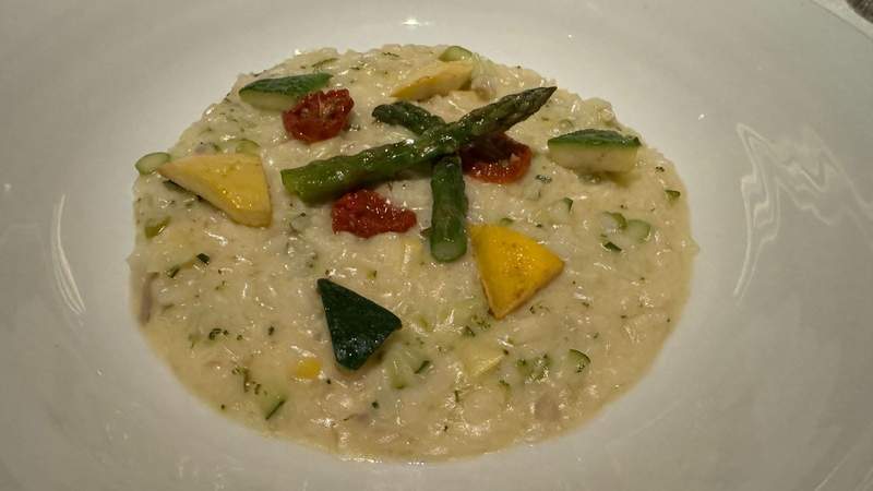 plate of risotto with yellow and green squash and asparagus on a plate on the celebrity xcel