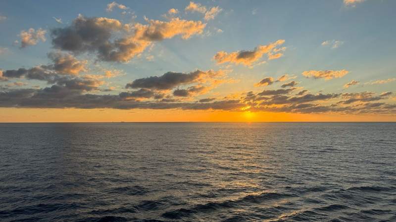 ocean view at yellow and orange sunset with clouds from the celebrity xcel.