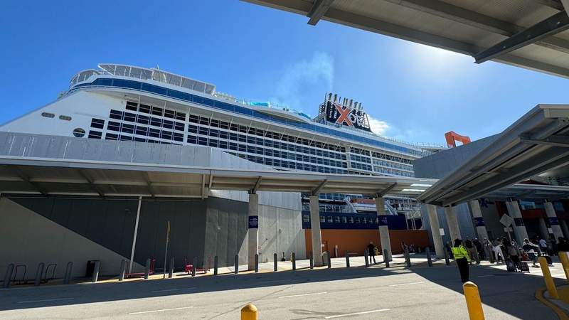 large celebrity xcel cruise ship and a crosswalk with cement pillars. 